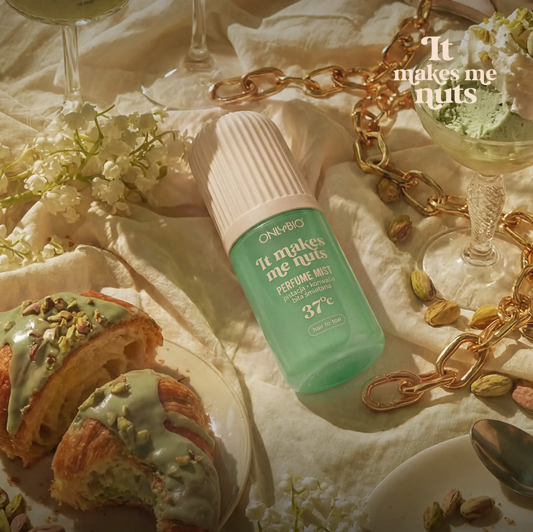 Mgiełka perfumowana ONLYBIO It Makes Me Nuts na stole wśród pistacjowych deserów i kwiatów.